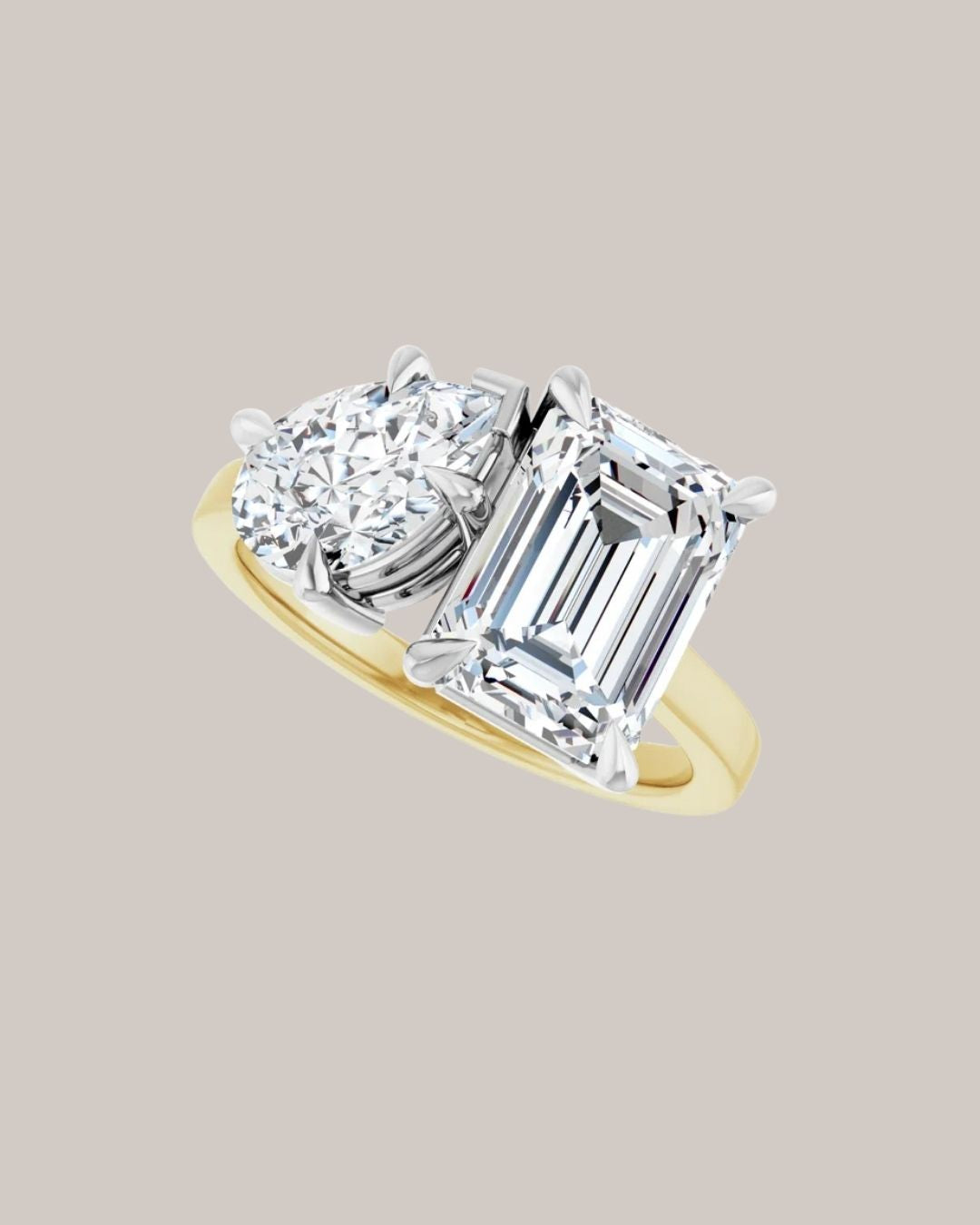 14K two tone gold two stone engagement ring shown with a 3.00 ct emerald cut and 2.00 ct pear shaped diamond