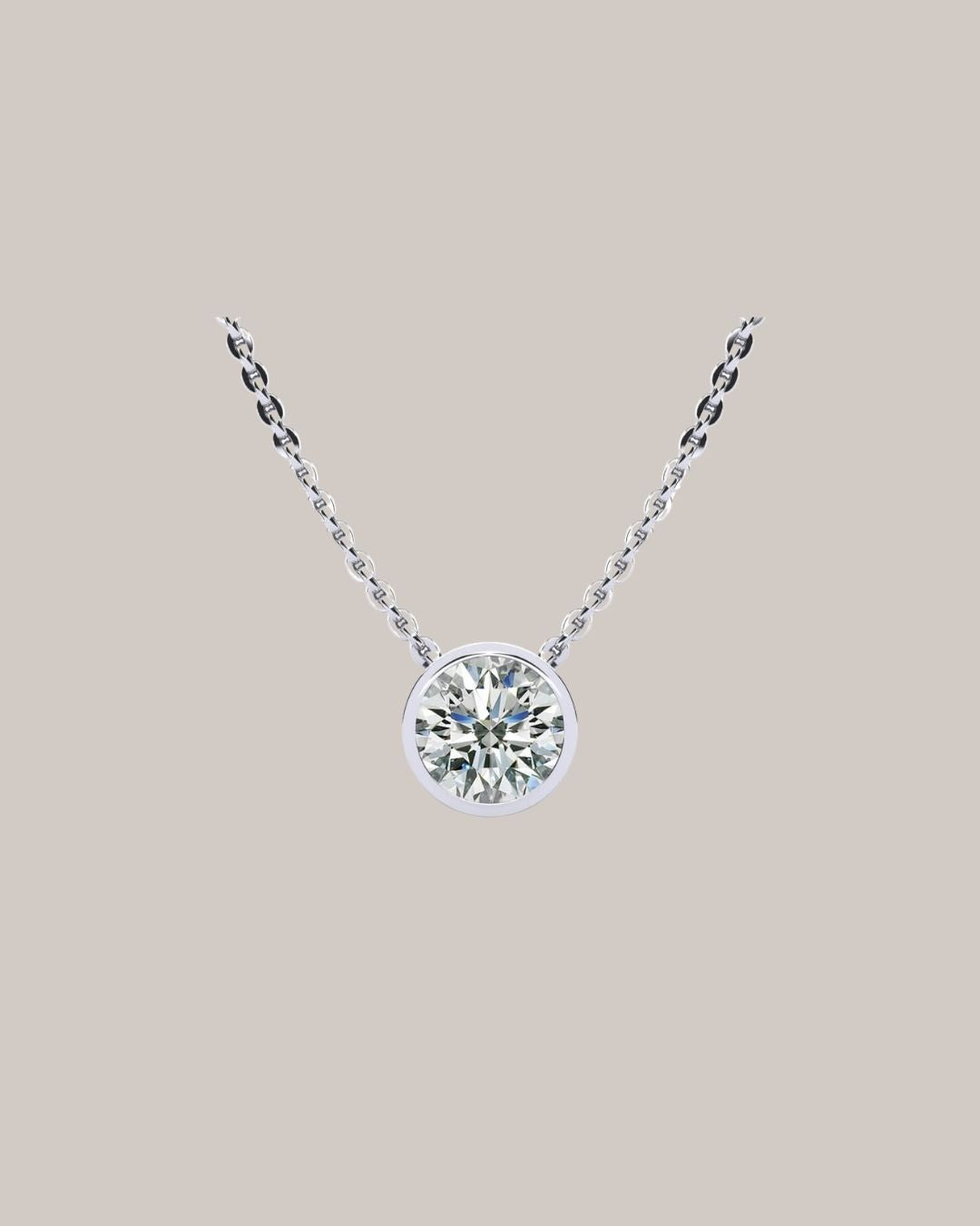 White gold 1.50 ct bezel set round diamond pendant on an 18 inch cable chain
