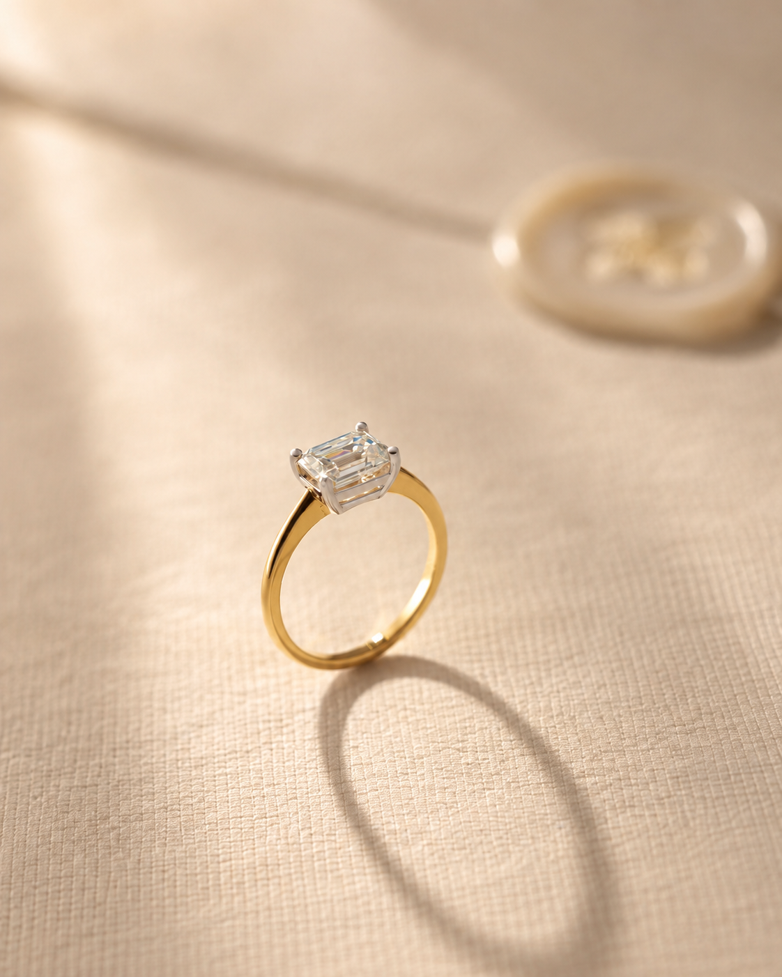 Two tone east west emerald cut solitaire engagement ring in 14K gold shown with a 1.75 ct centre diamond